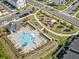 Aerial view of a community pool and playground, complemented by lush landscaping and nearby modern townhomes at 505 Hampton Crossing, Woodstock, GA 30188