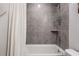 Modern bathroom featuring a white tub and shower with a tiled surround, complemented by a neutral color palette at 505 Hampton Crossing, Woodstock, GA 30188
