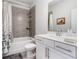 Bathroom featuring a bathtub with shower, tiled walls, white sink with vanity and neutral color scheme at 505 Hampton Crossing, Woodstock, GA 30188