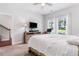 Bright bedroom with a ceiling fan, a TV on a dresser and white trim windows that let in lots of natural light at 505 Hampton Crossing, Woodstock, GA 30188