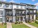 Exterior view of townhome with multiple balconies, green lawn and landscaping at 505 Hampton Crossing, Woodstock, GA 30188