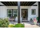Inviting front porch with black accents, a cozy bench, and colorful plants, creating a welcoming outdoor space at 505 Hampton Crossing, Woodstock, GA 30188