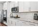 Modern kitchen with white cabinets, granite countertops, stainless appliances and tile backsplash at 505 Hampton Crossing, Woodstock, GA 30188