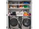 Laundry area boasts modern side-by-side washer and dryer, with shelving storage above at 505 Hampton Crossing, Woodstock, GA 30188