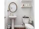 Cozy powder room with modern fixtures, decorative shelving, and pedestal sink at 505 Hampton Crossing, Woodstock, GA 30188