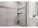 Elegant glass shower features gray tiling, decorative accent stripe, and built-in corner shelves at 505 Hampton Crossing, Woodstock, GA 30188
