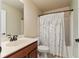Cozy bathroom featuring a white vanity with wood cabinets and a shower with a patterned curtain at 12148 Flannery Ln, Hampton, GA 30228