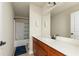 Bright bathroom with a large mirror, white countertops, wooden cabinets, and a shower with a blue curtain at 12148 Flannery Ln, Hampton, GA 30228
