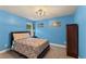 Comfortable bedroom with blue walls, a double bed, and wooden furniture, illuminated by modern lighting at 12148 Flannery Ln, Hampton, GA 30228