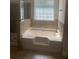 Bathroom featuring a tub and shower with tile surround and accent window at 2118 Water Mill Ct, Buford, GA 30519