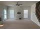 Spacious living room featuring neutral walls, carpet, fan, fireplace, and staircase at 2118 Water Mill Ct, Buford, GA 30519