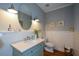 Charming powder room with a marble countertop, stylish fixtures, wainscoting, and wood flooring at 700 Broadlands Ln, Powder Springs, GA 30127