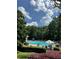 Inviting community pool surrounded by lush greenery, lounge chairs, and umbrellas at 700 Broadlands Ln, Powder Springs, GA 30127