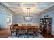 Elegant dining room with a coffered ceiling, wainscoting, a rustic wood table with seating, and hardwood floors at 700 Broadlands Ln, Powder Springs, GA 30127