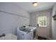 Functional laundry room with a washer, dryer, utility sink, and storage, leading to the exterior of the home at 700 Broadlands Ln, Powder Springs, GA 30127