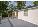 View of a spacious gray back deck with a white brick house and trees in the background at 7144 Carolyn Cir, Lithia Springs, GA 30122