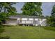 View of the home's backyard with a well-manicured lawn, patio, and beautiful white brick exterior at 7144 Carolyn Cir, Lithia Springs, GA 30122