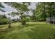 The backyard features a lush lawn, mature trees and a small wooden wishing well at 7144 Carolyn Cir, Lithia Springs, GA 30122