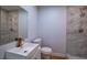 This renovated bathroom features marble tile and gold fixtures for a luxurious feel at 7144 Carolyn Cir, Lithia Springs, GA 30122