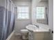A bathroom that offers lots of natural light with a shower and tub combo at 7144 Carolyn Cir, Lithia Springs, GA 30122