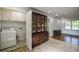 Neutral living room with vintage hutch, laundry area and bright window at 7144 Carolyn Cir, Lithia Springs, GA 30122