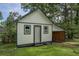 Exterior of a single-story shed featuring green trim and wooden sliding door at 7144 Carolyn Cir, Lithia Springs, GA 30122