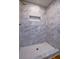 The beautifully tiled shower includes built-in shelving and a hexagon-tiled shower floor at 7144 Carolyn Cir, Lithia Springs, GA 30122
