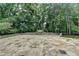 Spacious backyard stone patio with landscaping, mature trees, and a peaceful, private setting at 8230 Royal Melbourne Way, Duluth, GA 30097