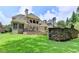 A spacious backyard with a large stone patio, lush lawn, and a stone wall, ideal for outdoor relaxation at 8230 Royal Melbourne Way, Duluth, GA 30097