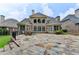 Expansive backyard with stone patio, well-maintained lawn, and mature landscaping creating a tranquil outdoor space at 8230 Royal Melbourne Way, Duluth, GA 30097