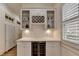 Bar area with wine storage, wine cooler, marble countertop, cabinets, and wine glass storage at 8230 Royal Melbourne Way, Duluth, GA 30097