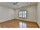 Bedroom featuring hardwood floors, crown molding, and shuttered windows at 8230 Royal Melbourne Way, Duluth, GA 30097