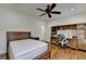 Bedroom with a dark wood frame bed, hardwood floors, a desk, shelving and a ceiling fan at 8230 Royal Melbourne Way, Duluth, GA 30097