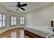 Corner bedroom with hardwood floors, two windows, a ceiling fan and a bed at 8230 Royal Melbourne Way, Duluth, GA 30097