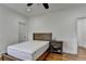 Neutral bedroom with a single bed frame, a dark wood nightstand and hardwood floors at 8230 Royal Melbourne Way, Duluth, GA 30097