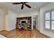 Bedroom featuring a built-in desk, hardwood floors, ceiling fan and an open doorway to a walk-in closet at 8230 Royal Melbourne Way, Duluth, GA 30097