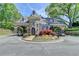 Stone gatehouse with archways, turret, and manicured landscape welcoming guests to the beautiful community at 8230 Royal Melbourne Way, Duluth, GA 30097