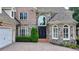 Grand brick home featuring a stone facade, arched windows, and a paved driveway at 8230 Royal Melbourne Way, Duluth, GA 30097