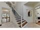 Elegant foyer with hardwood stairs, iron railings, and tiled flooring at 8230 Royal Melbourne Way, Duluth, GA 30097