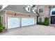 Spacious two-car garage with white doors and a lovely brick-paved driveway at 8230 Royal Melbourne Way, Duluth, GA 30097