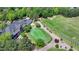 Aerial of stately clubhouse with golf practice area, golf carts, and lush landscaping at the golf course at 8230 Royal Melbourne Way, Duluth, GA 30097