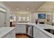 Bright, open kitchen featuring white cabinets, marble counters, stainless steel appliances, and an island at 8230 Royal Melbourne Way, Duluth, GA 30097