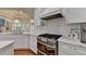 Bright kitchen features white cabinets, marble counters, modern appliances, and hardwood floors at 8230 Royal Melbourne Way, Duluth, GA 30097