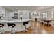 Bright, open kitchen featuring white cabinets, hardwood floors, marble counters, and a large island with barstool seating at 8230 Royal Melbourne Way, Duluth, GA 30097