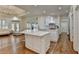 Open concept kitchen features white cabinets, marble counters, a large island, hardwood floors, and living space at 8230 Royal Melbourne Way, Duluth, GA 30097