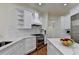 Bright kitchen features white cabinets, marble counters, modern appliances, an island, and hardwood floors at 8230 Royal Melbourne Way, Duluth, GA 30097