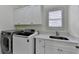 Laundry room with front loading washer and dryer, sink with marble countertop, and cabinets at 8230 Royal Melbourne Way, Duluth, GA 30097