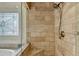 Walk-in shower featuring travertine tile, built-in bench, shower head and patterned accent tile at 8230 Royal Melbourne Way, Duluth, GA 30097
