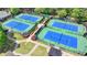 Aerial view of four tennis courts with bright blue surfaces and green borders at St. Marlo Country Club at 8230 Royal Melbourne Way, Duluth, GA 30097
