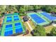 Aerial view of tennis and pickleball courts, showcasing the community's recreational amenities in a wooded setting at 8230 Royal Melbourne Way, Duluth, GA 30097